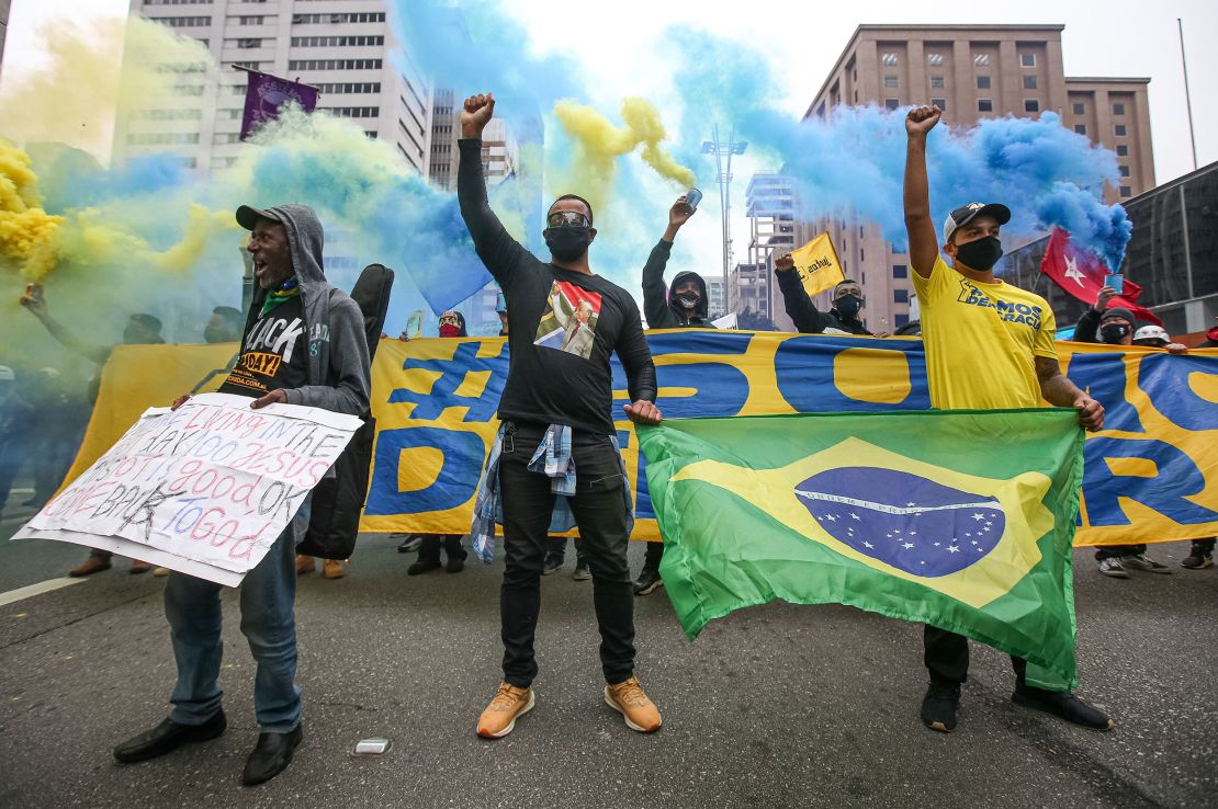 Demonstrators wearing face masks raise their fist on Paulista Avenue during a protest amidst the coronavirus (COVID-19) pandemic on June 14, 2020 in Sao Paulo, Brazil.