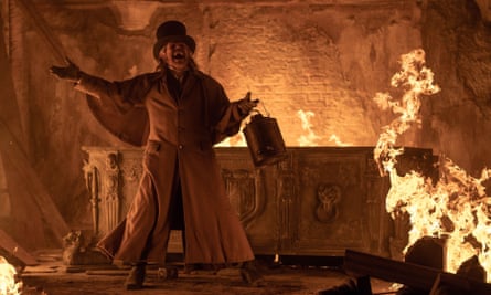 Willem Dafoe in Nosferatu as Prof Albin Eberhart Von Franz in a church as flames rise around him
