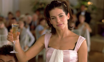 Sandra Bullock holding up a glass of champagne. 