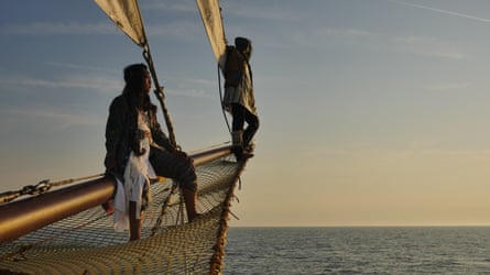 Filastine and Nova sitting on the bow of their sailboat.