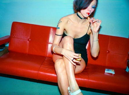 Ashley smoking on her red vinyl couch with the mechanical tongues she attached to the arms.