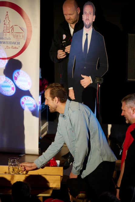 Harry Kane plays a form of curling with one-litre beer steins as his cardboard cutout looks on.