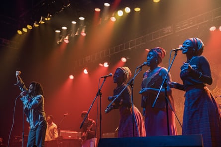 Still from Bob Marley: One Love shows Marley and his backing singers the I-Threes performing in concert