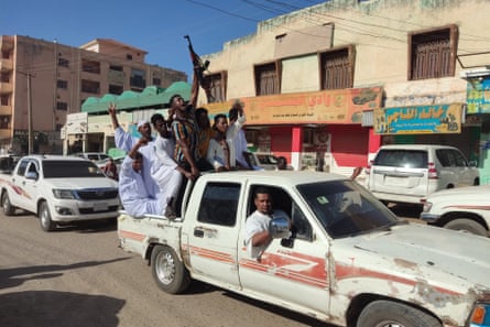 A truck of men, one holding a rifle, in Gadaref city, December 2023.