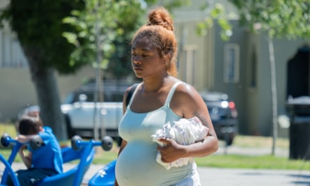 A pregnant Tia Nomore walking in the street. 