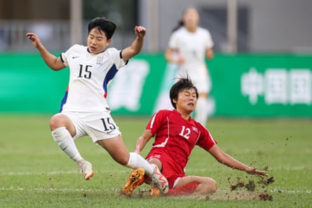 Chun Garam of South Korea and Choe Kum-ok of DPR Korea compete for the ball