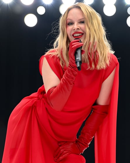 Kylie Minogue performing in a vivid red dress and gloves