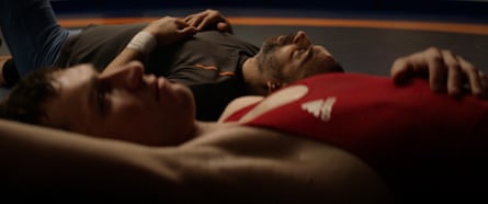 Two men in wrestling kit lying on the floor