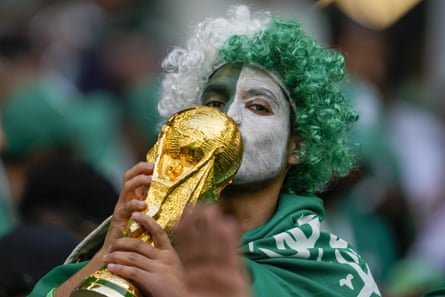 A Saudi Arabia supporter kisses a small replica of the World Cup trophy at the last tournament in Qatar.