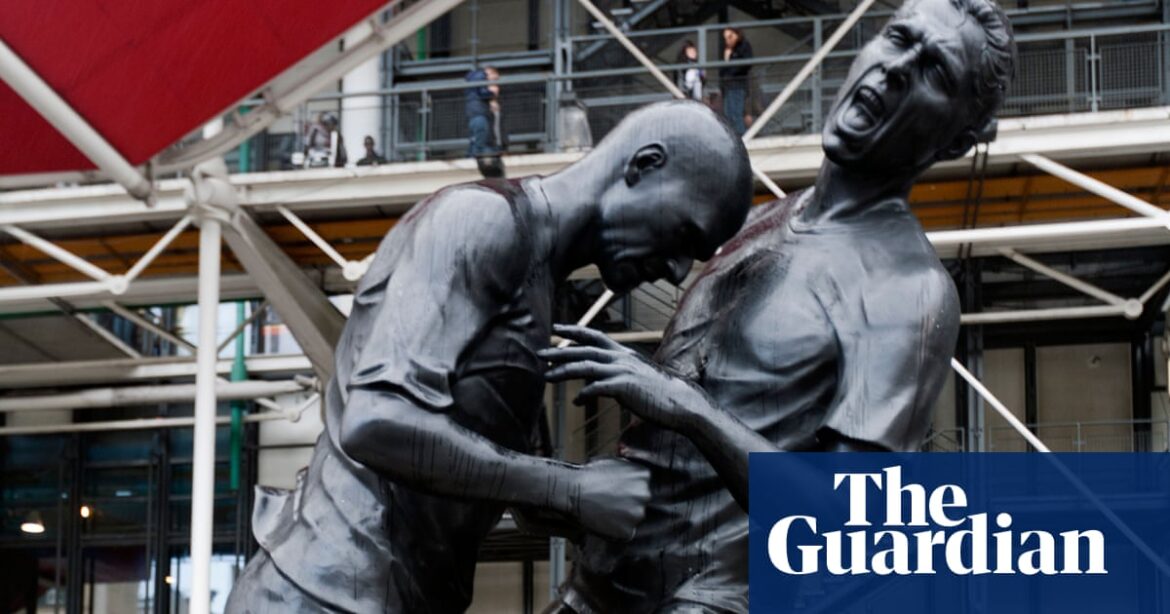 Several individuals are standing on top of a platform, resembling an eleven of football statues, as shown in the pictures.