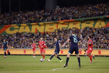 Jackson Irvine passes the ball with packed crowd in the background