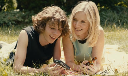 Samuel Kircher and Léa Drucker lying together on a patch of grass. 