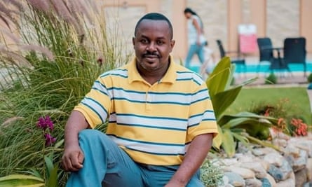 A smiling John Williams Ntwali posing for a photograph in a garden