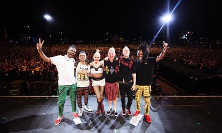 Group of people of various races and ethnicities with their arms around each other onstage.