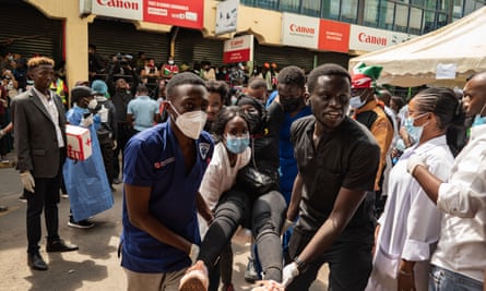 Volunteer medics carry an injured protester away from a crowd