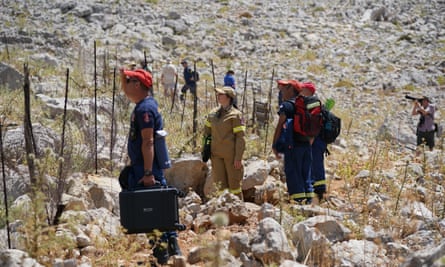 People on rocky ground wearing caps