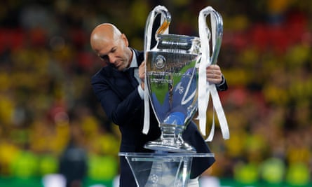 Zinedine Zidane, who won the European Cup as a player and manager with Real Madrid, places the trophy for the presentation at Wembley.