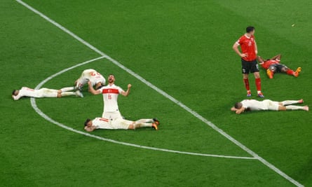 Turkey’s Salih Ozcan celebrates after the match as teammates collapse on the pitch following their victory against Austria