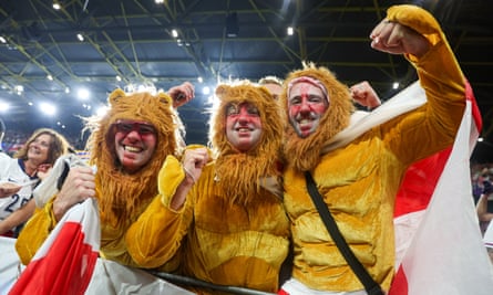 Three men dressed as three lions at a football match