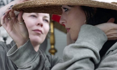 Dakota Fanning, in the foreground, tries on a hat while Olivia Colman, seen under the brim behind her, looks into the distance