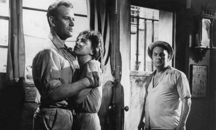 black and white film still of woman holding on to a man while another man looks on