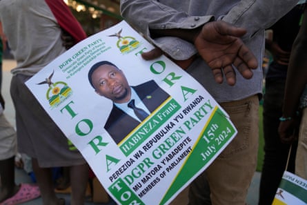 A supporter of Frank Habineza holds a poster of him during the Democratic Green party hopeful’s final election campaign rally in Kigali.