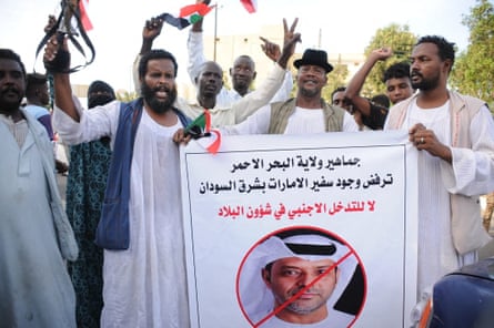 People dressed in white robes protesting against the UAE’s influence in Sudan. A slogan written in Arabic on a banner reads: ‘The people of (Sudan’s) Red Sea state reject the presence of the UAE ambassador in eastern Sudan. No to the foreign interference in the country’s affairs.’