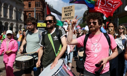 People marching with those in front banging drums