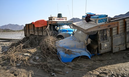 Trucks buried in the mud after the collapse of the Arbaat dam