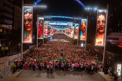 Fans leaving the stadium through lit-up billboards, directed by stewards with ‘STOP’ and ‘GO’ signs