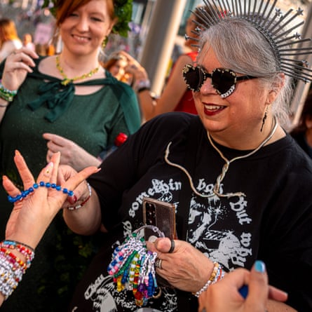 A woman in a starburst tiara holds a bundle of friendship bracelets