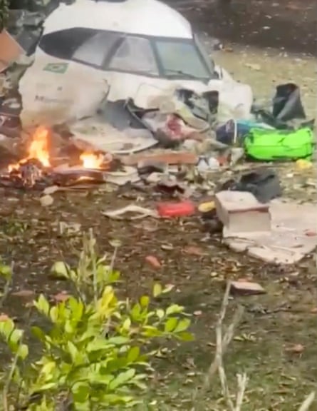 A cockpit lies destroyed on the ground and smolders.