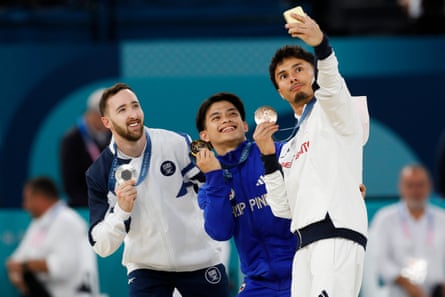 From left to right, silver medalist Artem Dolgopyat, of Israel, gold medalist Carlos Edriel Yulo, of the Philippines, and bronze medalist Jake Jarman, of Britain, take a selfie on the podium after the men’s artistic gymnastics individual floor finals.