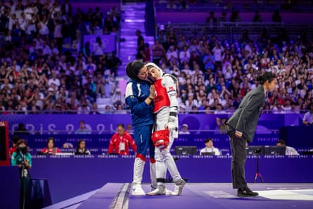 Nahid Kiyanichanden of Iran is consoled after being defeated by Yuin Kim of South Korea in their women’s taekwondo 57kg gold medal bout.