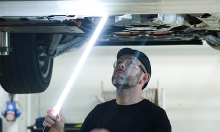 A worker inspecting a car at JLR's electric vehicle test facility in Whitley, Coventry