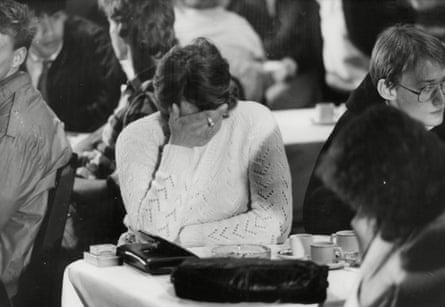 A woman reacts with her head in her hand, as if crying, at a special preview screening of Threads in 1984 for those who took part as extras.