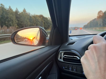 Sunset reflecting in a wing mirror … ‘I turn up the volume and let the beat propel me towards the shimmering lights of Hamburg.’