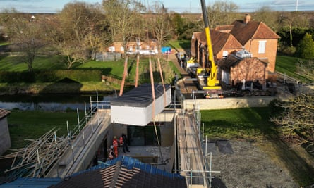 A spa pool is removed from a building at the Ingram-Moores’ house by crane.