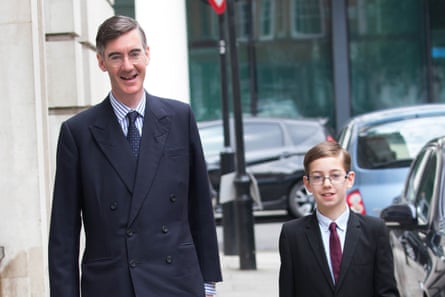 Rees-Mogg and his son, both in suit and tie, walking down a street.