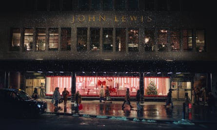 The John Lewis store on Oxford Street, its windows illuminated in the dark; light snow appears to be falling