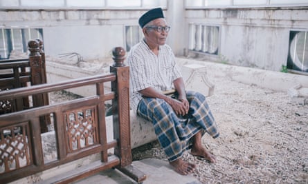 Zainal Abidin, 68, sits on the site where buildings were destroyed by the 2004 tsunami 