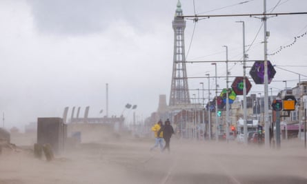 People rush away as sea overflows on to the street in front of Blackpool Tower.