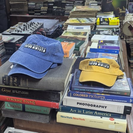 Blue and yellow caps saying ‘The Lijadu sisiters’ on piles of books