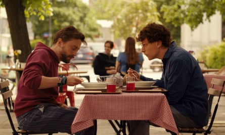 Two men eat at outdoor bistro table