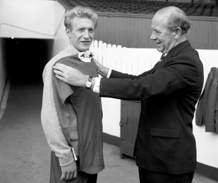 Matt Busby sizes up Denis Law for his Manchester United shirt after his transfer from Torino