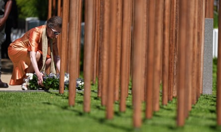 Princess Anne crouching down next to poles with flowers