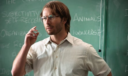 Glen Powell in front of a blackboard in Hit Man