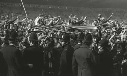 Manchester United fans invade the Old Trafford pitch with City ahead thanks to Denis Law’s goal in 1974.