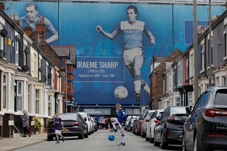 Children play football in a terraced street leading to Goodison. ‘Evertonians know we are – somehow, despite many false dawns – gaining an impossibly beautiful new stadium, a new future, even hope.’