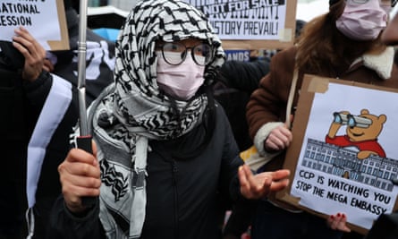 A protester wearing a face mask and black-and-white headscarf